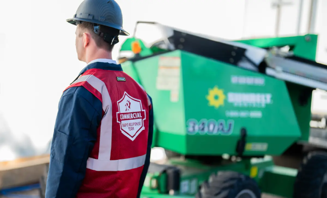 A service professional stands beside biohazard cleanup equipment.