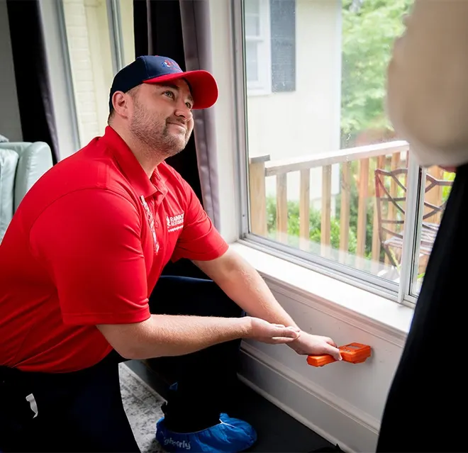A Rainbow Restoration expert checks for water damage in a wall at a Moody, AL, home using a moisture meter.