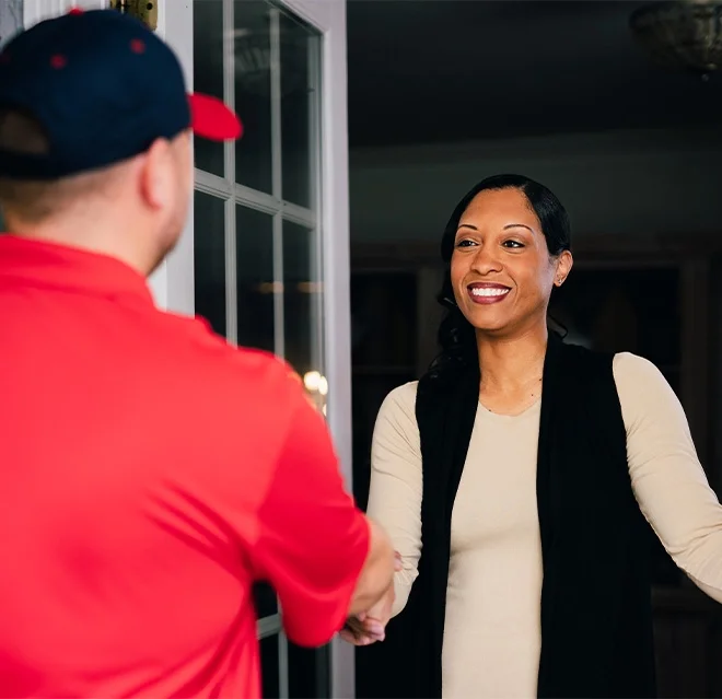 A homeowner in Elkton, VA, who called for emergency restoration services, greets a Rainbow Restoration expert at their front door. 