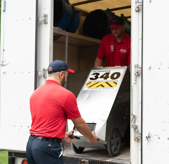 Rainbow Restoration technicians unload water damage equipment at a residential property damage loss in Universal City, TX.
