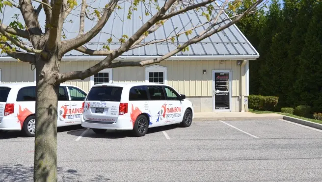Two Rainbow Restoration of Northeastern Maryland service vans parked outside the branch office before heading out to a heating oil cleanup job.