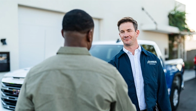 A Rainbow Restoration service professional shakes hands with a customer in need of emergency response property restoration services.