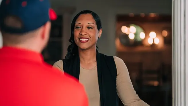 A homeowner in Boiling Springs, SC, in need of emergency restoration services, greets a Rainbow Restoration service professional at their front door.