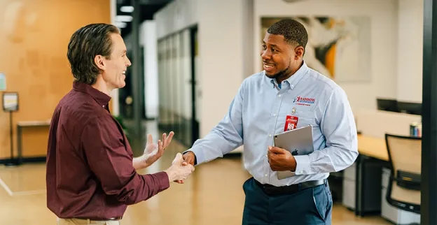 A Rainbow Restoration service professional greets a commercial restoration customer.