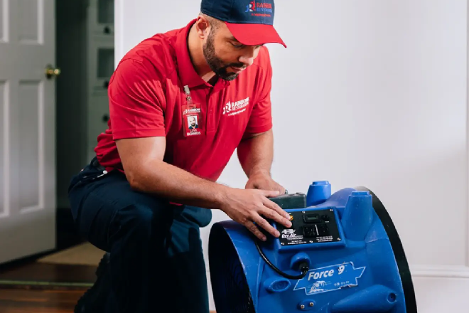 A Rainbow Restoration service professional cleans and sanitizes an area during sewage cleanup.