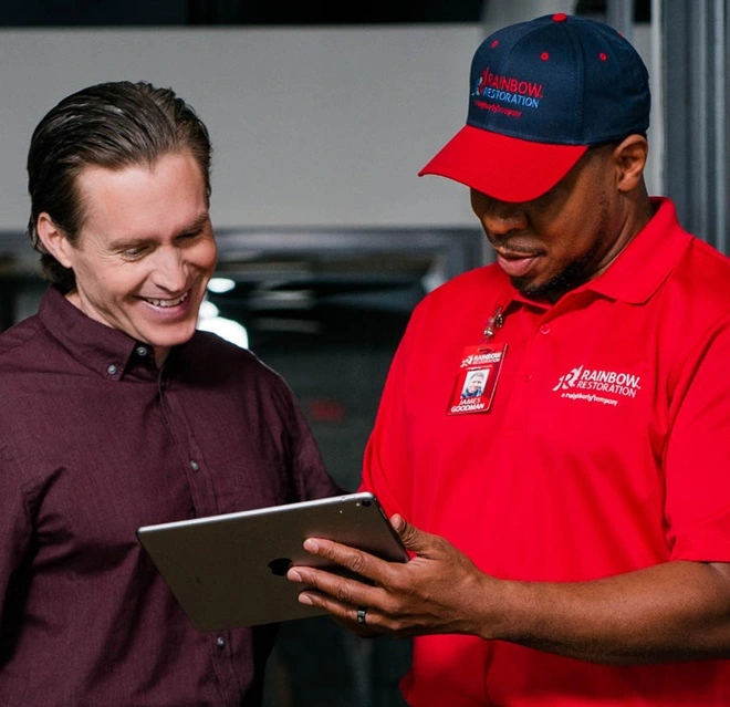 A Rainbow Restoration service professional speaking with a customer about residential air duct cleaning.