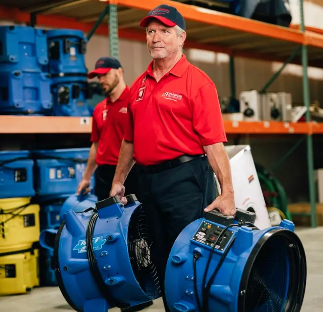 Rainbow Restoration service professionals carrying high-powered fans. 