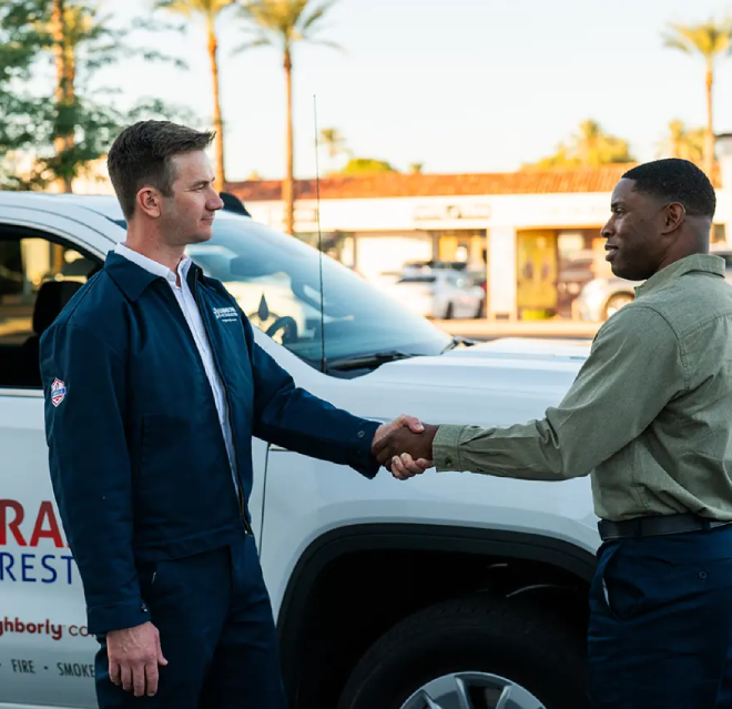 A Rainbow Restoration service professional shakes hands with a client.