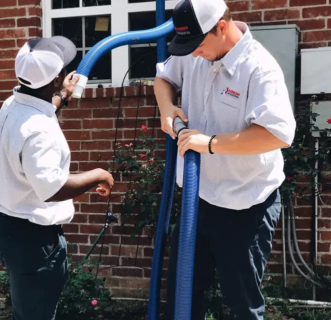 A Rainbow Restoration service professional smiling with hard hat and goggles.
