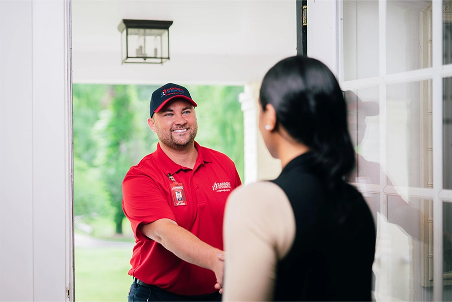 A Rainbow Restoration expert greets a Five Forks, SC, homeowner in need of emergency restoration services at their front door.
