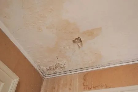 Water damage on the ceiling of a room.