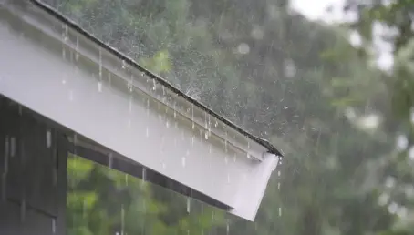 Heavy fall rainfall coming down on a home’s gutters